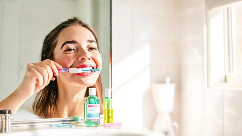 Persona sonriente cuidando su higiene dental