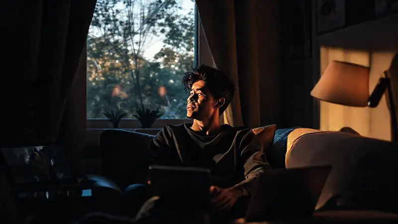 Persona reflexiva en habitación confortable y tecnológica