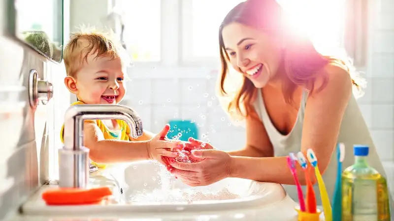 Niño feliz lavándose las manos con alegría