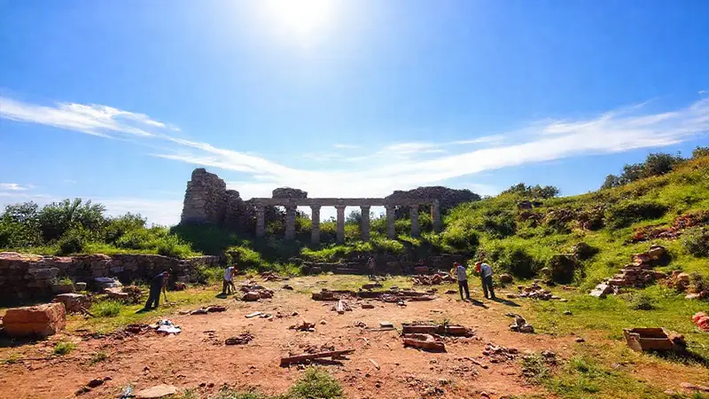 Ruinas antiguas y arqueólogos en un paisaje