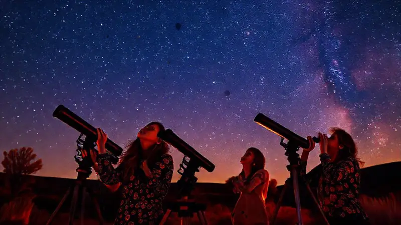 Astrónomas observan estrellas en una noche estrellada